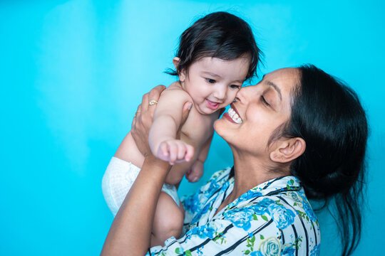Mother tenderly holding her newborn in soft warm light at home