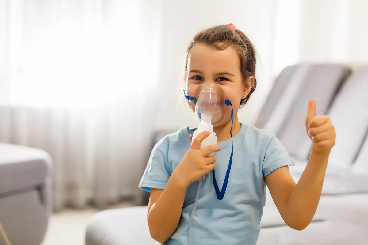 A child breathing calmly through a nebulizer mask