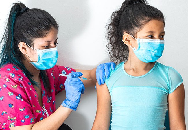 Mother holding her baby close during a vaccination visit at Happy Kids Clinic, Wagholi