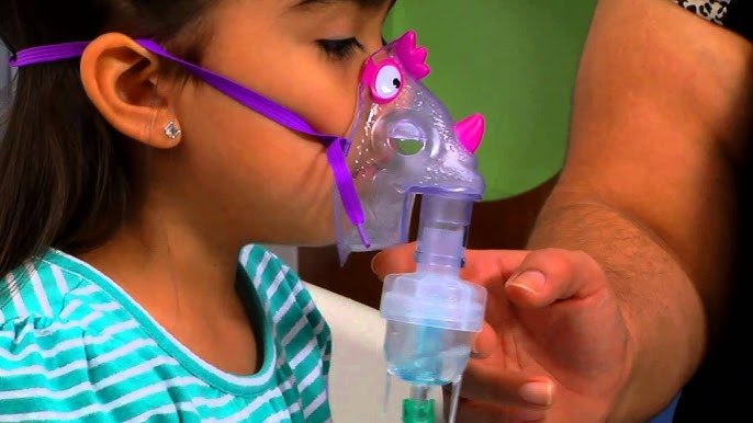 Child breathing calmly through a nebulizer mask during allergy care