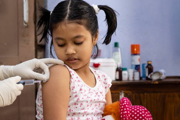 A pediatrician gently administering a vaccination to a baby