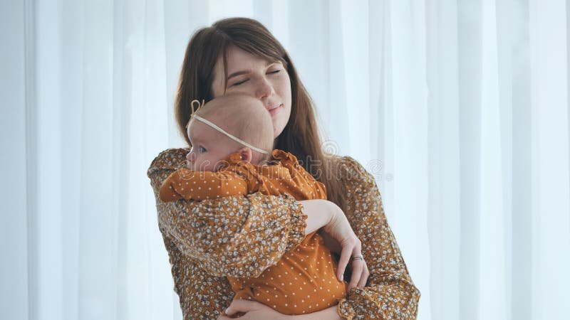A mother cradling her newborn in soft warm light at home