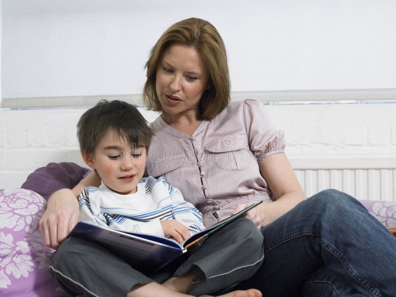 Parents reading a picture book with their two children at home